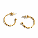 A pair gold hoop earrings on a white background.