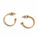 A pair gold hoop earrings on a white background.