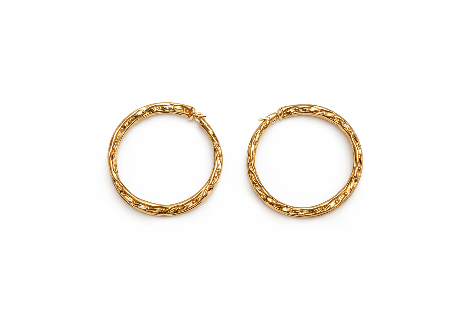 A pair of gold hoop earrings on a white background