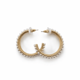 A pair of golden pearl hoops on a white background.
