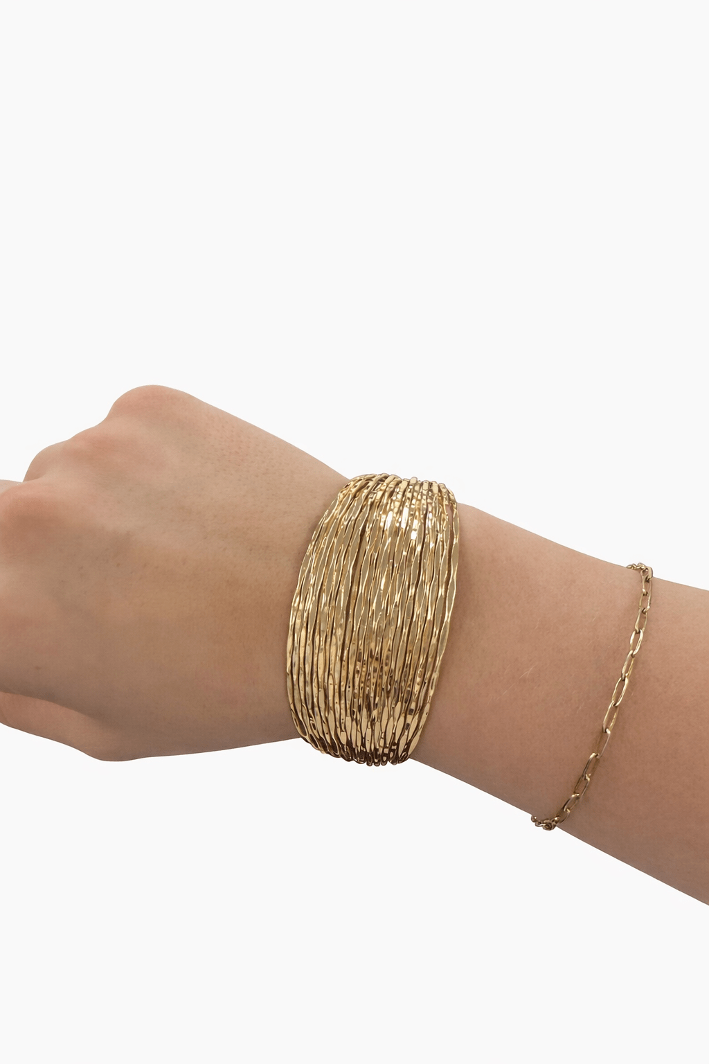 Gold bracelet on a wrist against a white background