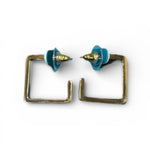 Pair of earrings with square frames and blue tops on a white background
