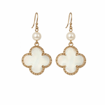 Pair of earrings with white floral designs and pearl-like beads on a white background