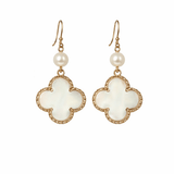 Pair of earrings with white floral designs and pearl-like beads on a white background